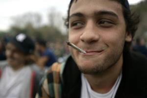 A young man smokes a marijuana cigarette at a park where people gathered to mark the First Worldwide March for Regulated Marijuana in Montevideo, Uruguay, Saturday, May 3, 2014. 