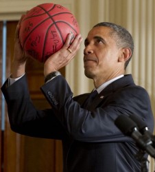 US President Barack Obama pretends to shoot a basketball given to him by the University of Kentucky men’s basketball team during an event celebrating their 2012 NCAA championship in the East Room of the White House in Washington, DC, on May 4, 2012. AFP PHOTO / Saul LOEB
