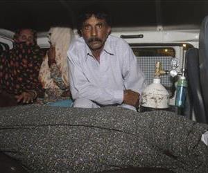 Muhammad Iqbal, right, husband of Farzana Parveen, 25, sits in an ambulance next to the body of his pregnant wife who was stoned to death by her own family, in Lahore, Pakistan.